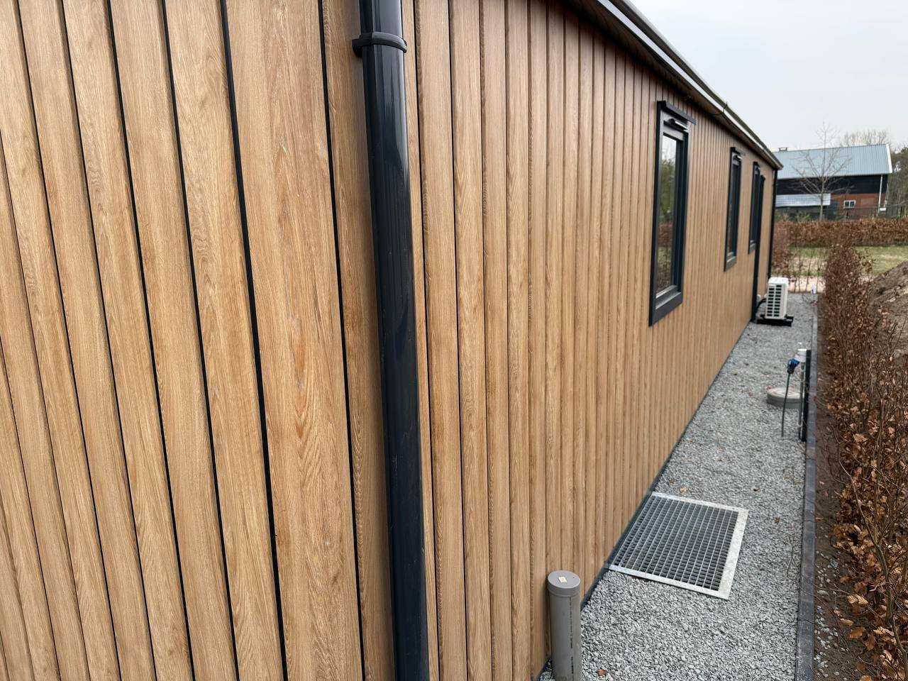 Nette leidingroute en strakke afwerking van airco-installatie langs chaletgevel